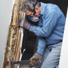 Man,Removing,Wood,Damaged,By,Termite,Infestation,In,House.