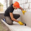 Worker,Applies,Bitumen,Mastic,On,The,Foundation